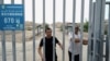 FILE - This picture taken on July 19, 2023, shows men at the gates of a Uyghur cemetery in Yengisar in northwest China's Xinjiang region.