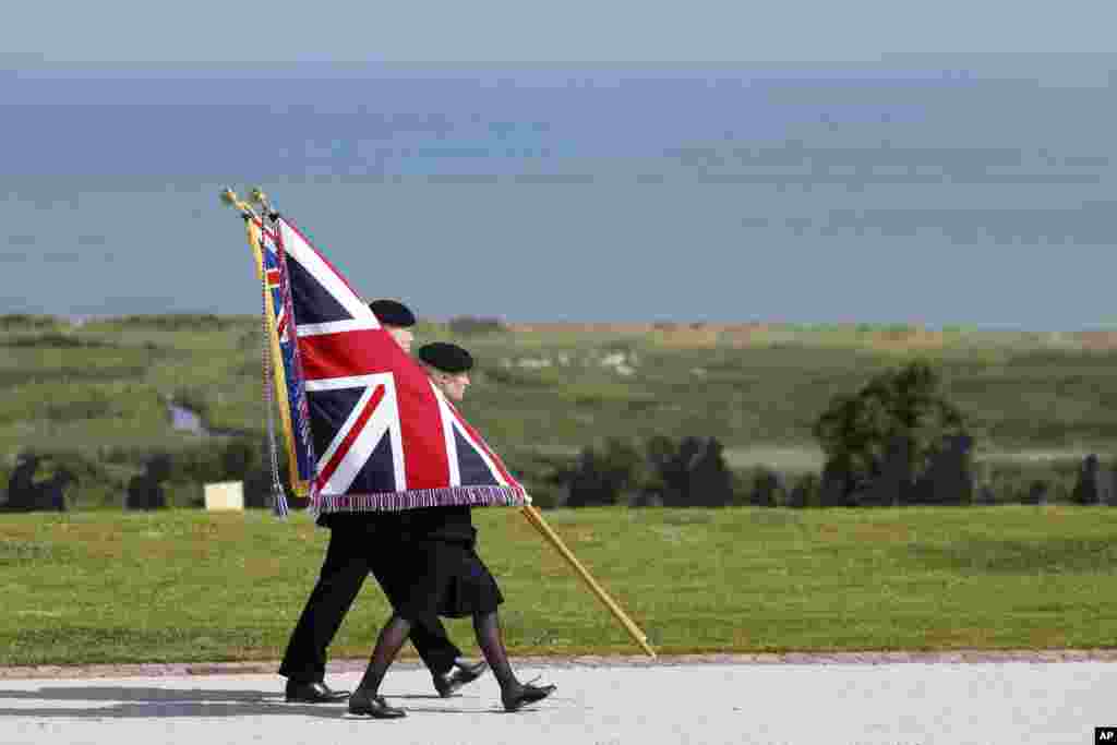 Youth carry the Union Flag during a commemorative ceremony marking the 80th anniversary of the World War II D-Day" Allied landings in Normandy, at the World War II British Normandy Memorial of Ver-sur-Mer, June 6, 2024. 