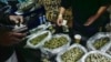 FILE - A vendor makes change for a marijuana customer at a cannabis marketplace in Los Angeles, April 15, 2019. 