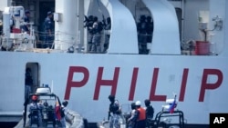 Personel penjaga laut Filipina berjaga di atas kapal PCG Melchora Aquino saat latihan Coast Guard di perairan Bataan, Filipina, Selasa, 6 Juni 2023. (Foto: AP)
