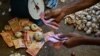 ILUSTRASI - Seorang vendor memegang uang kertas Sri Lanka saat bekerja di sebuah pasar di Kolombo, 13 Desember 2023. (Ishara S.KODIKARA/AFP). IMF mencapai kesepakatan tingkat staf dengan Sri Lanka, untuk membuka jalan bagi pencairan dana 337 juta dolar AS. 