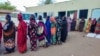 Internally displaced women wait in a queue to collect aid from a group at a camp in Gadaref on May 12, 2024, while clashes reignited between the Sudanese army and rival paramilitaries in the key Darfur town of El Fasher.