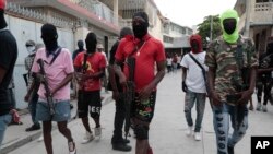 Angggota kelompok senjata "G9 and Family" berkumpul untuk melancarkan aksi protes terhadap Perdana Menteri Haiti Ariel Henry di Port-au-Prince pada 19 September 2023. (Foto: AP/Odelyn Joseph) 