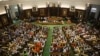 FILE- Newly elected lawmakers from India's ruling alliance led by the Hindu nationalist Bharatiya Janata Party raise their hands in support of Narendra Modi being elected their leader in New Delhi, May 25, 2019. 