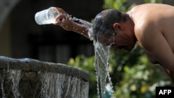 Seorang pria mendinginkan dirinya dengan air dari air mancur pada salah satu hari terpanas gelombang panas ketiga di Guadalajara, negara bagian Jalisco, Meksiko, pada 12 Juni 2023. (Foto: AFP)