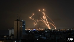 An Israeli missile launched from the Iron Dome missile defense system attempts to intercept a rocket fired from the Gaza Strip, over Netivot in southern Israel on October 8, 2023. (Mahmud Hams/AFP)