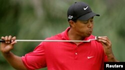 FILE - Tiger Woods blows on his putter on the 10th hole during final round play of the Tournament Players Championship golf tournament at the TPC at Sawgrass in Ponte Vedra, Florida, May 13, 2007. 