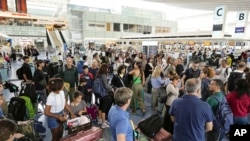 Passengers are seen at the international flight terminal at the Haneda airport, in Tokyo as a strong typhoon approaches Tokyo area, Aug. 16, 2024. 