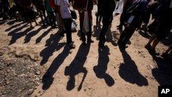 FILE - Para migran menunggu untuk diproses oleh Bea Cukai dan Patroli Perbatasan AS setelah mereka melintasi Rio Grande dan memasuki AS dari Meksiko di Eagle Pass, Texas, 19 Oktober 2023. (AP/Eric Gay, File)
