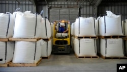 FILE - A worker moves bags of lithium carbonate at an Albemarle Corp. facility, Oct. 6, 2022, in Silver Peak, Nevada. The North Carolina company will pay millions to settle foreign bribery allegations, the U.S. Justice Department said Sept. 29, 2023.