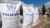 FILE - Displaced Palestinians wait to receive United Nations Relief and Works Agency (UNRWA) aid, amid the ongoing conflict between Israel and the Palestinian Islamist group Hamas, in Rafah, in the southern Gaza Strip, March 7, 2024. 