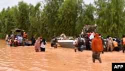 This photograph taken Aug. 20, 2024 shows police boats being used to carry people following heavy rains that damaged National Road 25 from the Nigerien capital Niamey to the provinces of Tillabéri and Tahoua in western Niger. 