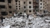 Police officers and local residents inspect damage outside a destroyed high-rise building following a Russian missile attack in central Kyiv, Jan. 3, 2024.