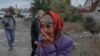 Seorang perempuan tampak menangis di jalan setelah sebuah serangan roket menghantam wilayah Mykolaiv, Ukraina, pada 23 Oktober 2022. (Foto: AFP/Bulent Kilic)