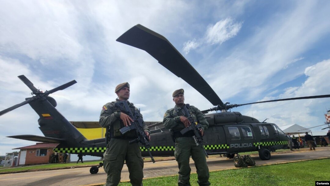 Dos agentes junto a los helicópteros Black Hawk remodelados para la protección del medio ambiente, el 26 de octubre de 2022, en la base de antinarcóticos de la Policía de Colombia, en San José del Guaviare. 