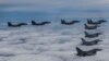 In this photo provided by South Korea Defense Ministry, South Korean Air Force's F15K fighter jets and U.S. Air Force's F-16 fighter jets, fly in formation during a joint drill in an undisclosed location in South Korea, Tuesday, Oct. 4, 2022. The South Ko