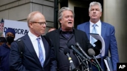 Former White House strategist Steve Bannon, center, speaks with members of the press after departing the federal court, July 18, 2022, in Washington. Standing with Bannon are his attorneys David Schoen, left, and M. Evan Corcoran.