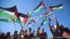 Sejumlah demonstran asal Palestina mengibarkan bendera Palestina dalam aksi protes menentang kunjungan Presiden AS Joe Biden ke Israel. Aksi tersebut digelar di Kota Gaza pada 14 Juli 2022. (Foto: AFP/Mohammed Abed)