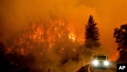 Sebuah mobil pemadam kebakaran tampak melintas di jalan raya besar California 96 di tengah kebakaran McKinney yang melanda wilayah Klamath National Forest, California, pada 30 Juli 2022. (Foto: AP/Noah Berger)