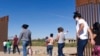 FILE - Brazilian migrants make their way around a gap in the U.S.-Mexico border in Yuma, Ariz., seeking asylum in the U.S. after crossing over from Mexico, June 8, 2021. 
