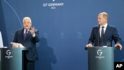 Palestinian President Mahmoud Abbas, left, speaks during a news conference after a meeting with German Chancellor Olaf Scholz, right, at the Chancellery in Berlin, Aug. 16, 2022.