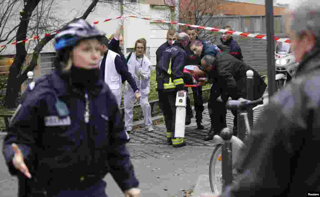 Firefighters carry a victim on a stretcher after a terror attack at the Paris offices of Charlie Hebdo, a satirical weekly paper, Jan. 7, 2015.