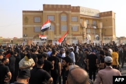 Pendukung ulama Syiah Irak Muqtada al-Sadr meneriakkan slogan-slogan saat mereka berkumpul di luar markas pemerintah daerah di kota Nasiriyah di provinsi Dhi Qar selatan Irak, 29 Agustus 2022. (Foto: AFP)