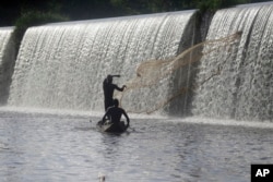 Fishermen cast a net near a dam that sources the sacred Osun River in Esa-Odo, Nigeria, on May 28, 2022.
