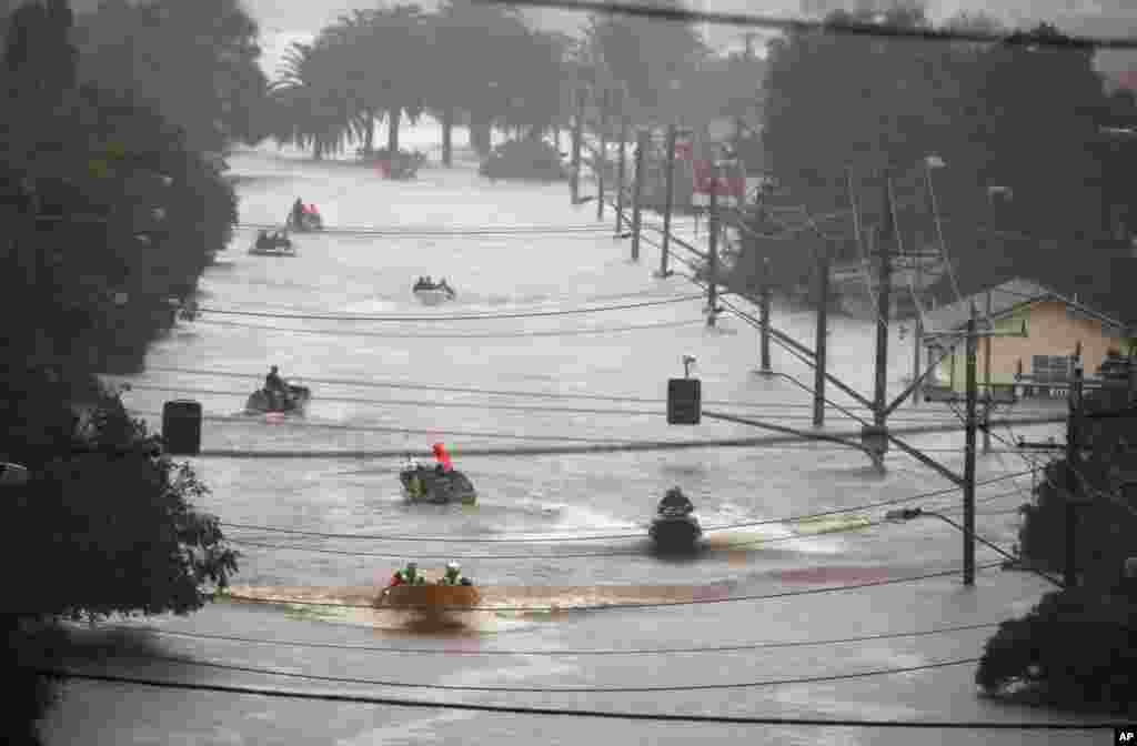 People use small boats to travel through flood water in Lismore, Australia.