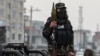 Seorang anggota pasukan Taliban berdiri memegang roket peluncur granat di sebuah kendaraan yang melaju di area Kabul, Afghanistan, pada 21 Januari 2022. (Foto: AFP/Mohd Rasfan)