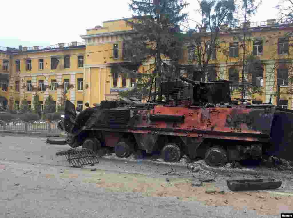 A destroyed armored vehicle is seen in front of a school which, according to local residents, was on fire after shelling, as Russia's invasion of Ukraine continues, in Kharkiv, Ukraine, Feb. 28, 2022.