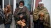 Para warga Afghanistan mengantri untuk menerima roti gratis yang dibagikan sebagai bagian dari kampanye melawan kelaparan di sebuah toko roti di Kabul, Afghanistan, pada 18 Januari 2022. (Foto: AFP/Wakil Kohsar)