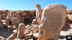 This photo provided by Jordan's Tourism Ministry shows two carved standing stones at a remote Neolithic site in the country’s eastern desert. 
