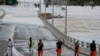 Tim Penanggulangan Keadaan Darurat Negara berdiri di dekat pintu masuk jembatan Windsor yang terendam banjir di pinggiran Sydney, Australia, Kamis, 3 Maret 2022. (Foto AP/Rick Rycroft)