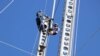 FILE- Workers for the country's electricity supplier ESCOM work on electricity poles damaged by Tropical Storm Ana, in Chikwawa district, Malawi. (Lameck Masina/VOA)