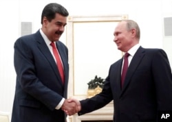 FILE - Russian President Vladimir Putin, right, shakes hands with Venezuela's President Nicolas Maduro during their meeting in the Kremlin in Moscow, Russia, Sept. 25, 2019.