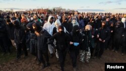 Para aktivis berdemonstrasi di Luetzerath, sebuah desa yang akan dihancurkan untuk perluasan tambang batu bara Garzweiler milik perusahaan utilitas RWE, Jerman, Minggu 8 Januari 2023.