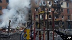 Idara ya wafanyakazi wazima moto yazima moto kwenye eneo la tukio baada ya shambulio la makombora ya Russia, nje ya mji mkuu Kyiv, Novemba 23, 2022. Picha ya AP