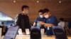 A customer talks to sales assistants in an Apple store as Apple new iPhone 14 models go on sale in Beijing, September 16, 2022. (REUTERS/Thomas Peter)