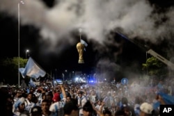 Tiruan trofi Piala Dunia FIFA tergantung di pintu masuk tempat latihan Asosiasi Sepak Bola Argentina, tempat latihan Tim Juara Piala Dunia 2022 yang akan menjadi tempat bermalam setelah mereka mendarat di bandara Ezeiza di pinggiran Buenos Aires, Argentina, Selasa, 20 Desember , 2022. (AP Photo/Rodrigo Abd)