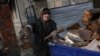 A woman loads firewood in the formerly Russian occupied city of Lyman, Donetsk region of Ukraine, Dec. 11, 2022. 