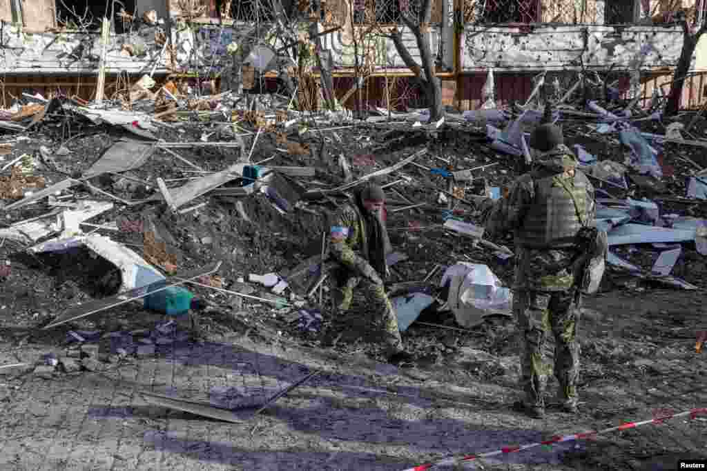 Ushtarët ukrainas inspektojnë dëmet në një ndërtesë banimi pas bombardimeve ruse në Kiev, më 15 mars 2022. 