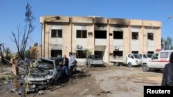 Mobil dan gedung yang rusak akibat ledakan di dekat markas polisi di kota Zliten, Libya, 7 Januari 2016.