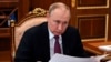 Presiden Rusia Vladimir Putin mendengarkan Gubernur Daerah Otonomi Yamalo-Nenets Dmitry Artukhov selama pertemuan mereka di Moskow, Rusia, Senin, 21 Maret 2022. (Foto: via AP)