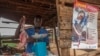 FILE - A butcher prepares goat meat next to a UNICEF poster calling on people to take precautions to protect themselves against cholera, in Likuni, outside Lilongwe, Malawi, Jan. 27, 2018. 