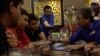 Johari Ghani, 58, right, a candidate for parliament, talks with several young voters. Conversations like these have become common on the campaign trail for the upcoming Malaysian general election. (Dave Grunebaum/VOA)