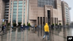 FILE - People walk outside the Justice Palace, in Istanbul, Sept. 20, 2019. Two reporters for the U.S.-based Bloomberg news agency appeared in court on Friday accused of trying to undermine Turkey's economic stability with a story they wrote the year prior.