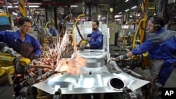 FILE - Iranian car workers weld parts of a car body, at the state-run Iran Khodro automobile manufacturing plant, which they claim is the largest car maker in the Middle East, near Tehran, Iran, April 20, 2011.