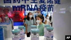 Sejumlah pengunjung mengamati botol replika vaksin COVID-19 buatan Sinopharm dalam acara Pameran Internasional Perdagangan dan Jasa China di Beijing, China, pada 5 September 2021. (Foto: AP/Ng Han Guan)