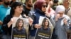 Des Palestiniens tiennent des photos de la journaliste d'Al Jazeera Shireen Abu Akleh, qui a été tuée par des tirs de l'armée israélienne lors d'un raid, à Naplouse, en Cisjordanie occupée par Israël, le 11 mai 2022. 